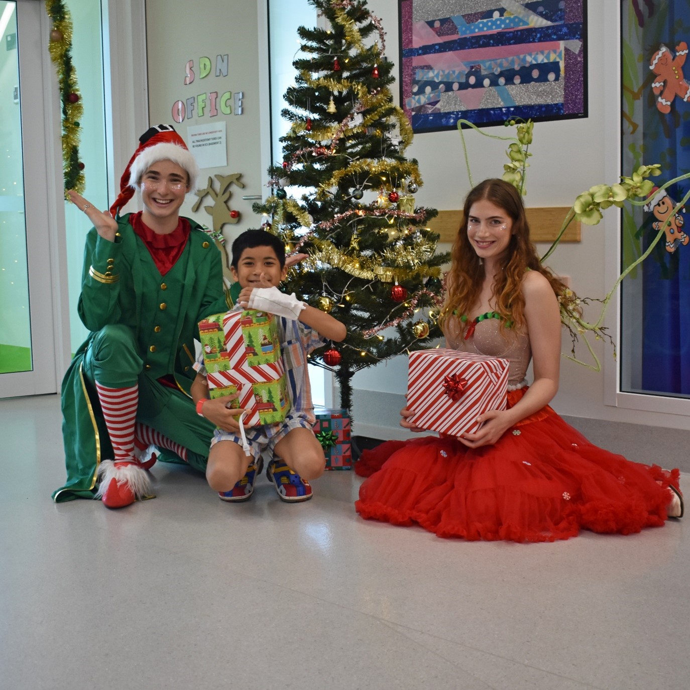 Christmas elf and fairy with a patient on a ward at Perth Children's Hospital.