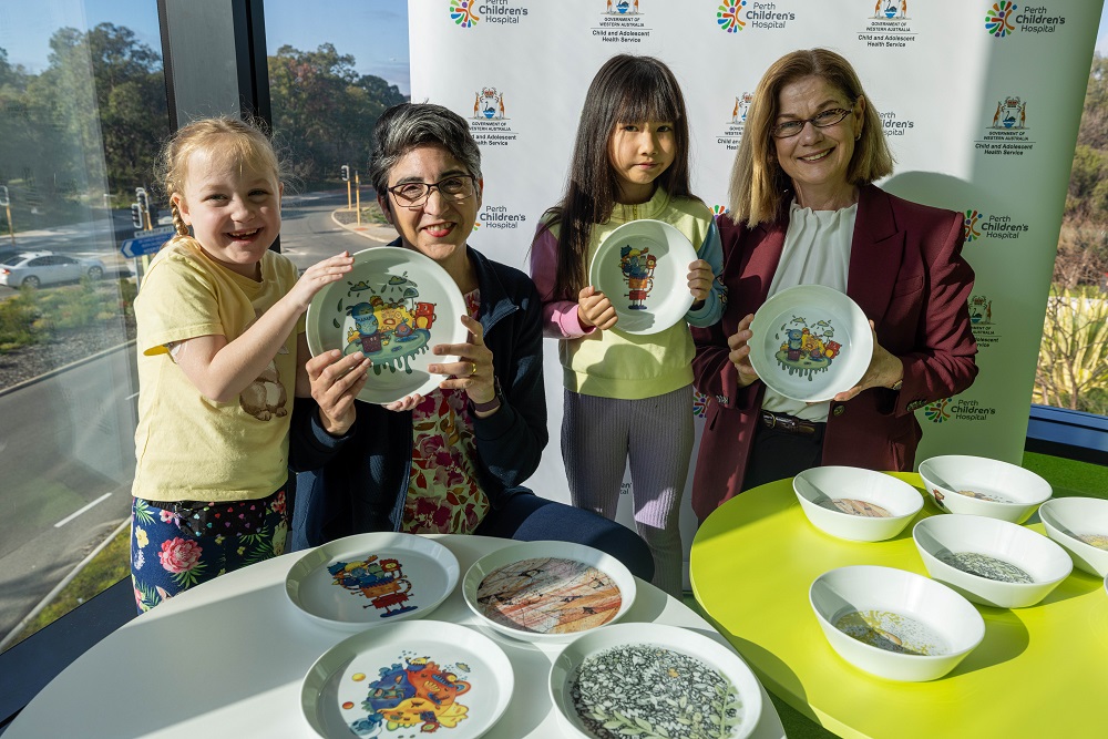 Hailey, artist Annie Aiton, Maddison and Hon Meredith Hammat admire the new patient plates at Perth Children's Hospital