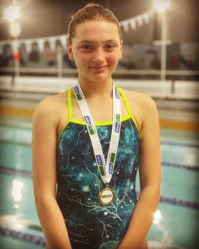Samantha at the swimming pool with a medal